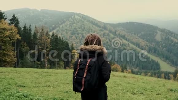镜头跟随年轻女孩徒步穿越山谷的山景跳跃微笑举起手臂飞向空中视频的预览图