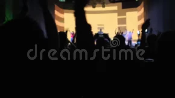 人们的身影在黑暗中随着乐队起舞鼓掌视频的预览图