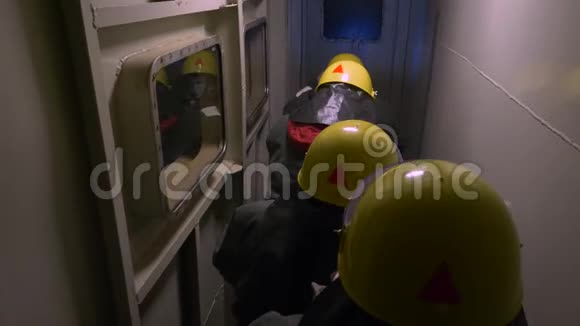 在黑暗隧道进行救援行动背部观看防护服和黄色头盔的救援视频的预览图