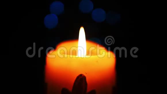 在一个黑暗的房间里装饰物在圣诞蜡烛上燃烧温暖的黄色蜡烛在黑暗中轻轻燃烧视频的预览图