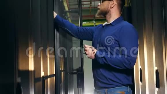 男工程师正试图将电缆插入服务器视频的预览图