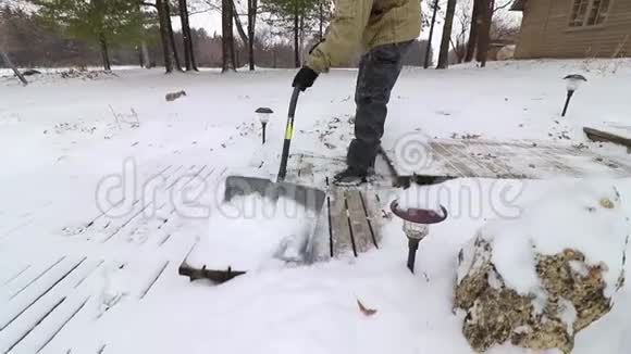 一个人缓慢地从木天井中铲雪视频的预览图