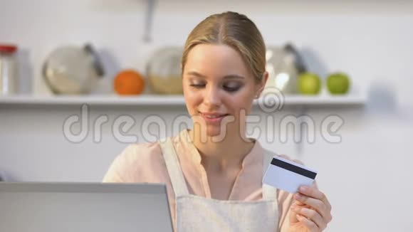 微笑的家庭主妇用信用卡在线支付接受产品交付视频的预览图