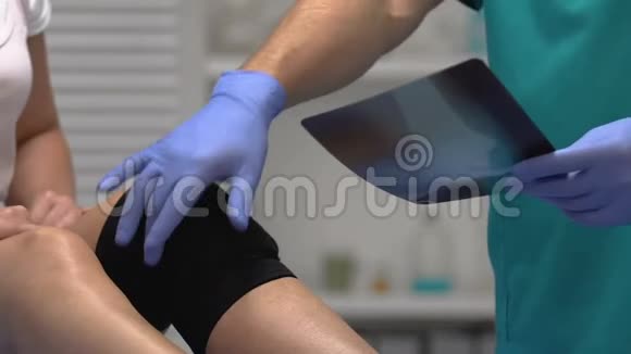 医生向受压迫的膝盖支架患者解释x光结果外伤视频的预览图