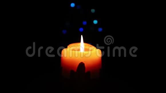 在一个黑暗的房间里放大圣诞蜡烛上的装饰物温暖的黄色蜡烛在黑暗中轻轻燃烧视频的预览图