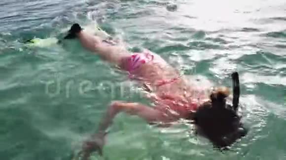 带着面具和浮潜在浅水中潜水的少女视频的预览图