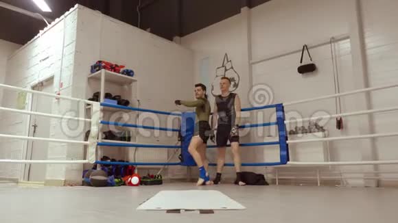 运动员在搏击俱乐部里做杂技轮在环边翻滚视频的预览图