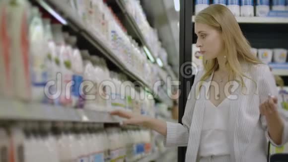 女性在杂货店选择和购买新鲜的有机乳制品视频的预览图