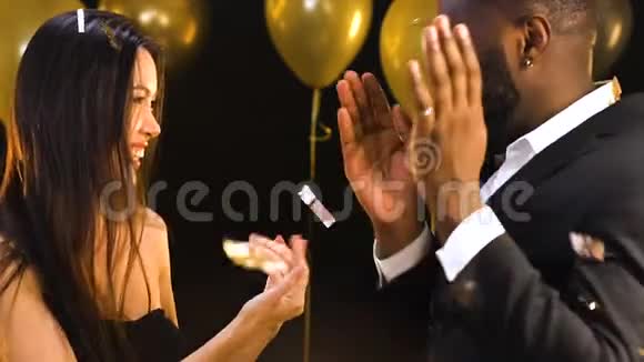 不错的多种族夫妇在派对上跳舞在飘落的纸屑下快乐在一起视频的预览图