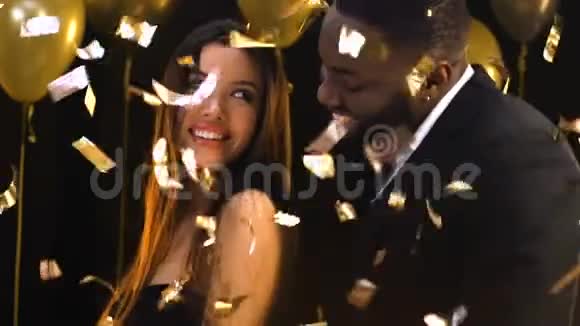多种族的情侣在坠落的纸屑下调情跳舞一夜情视频的预览图