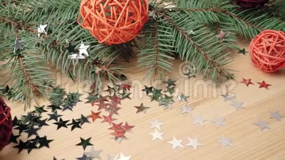 新年和圣诞节装饰一些礼物木制的彩色球和银星星靠近圣诞树树枝新年视频的预览图