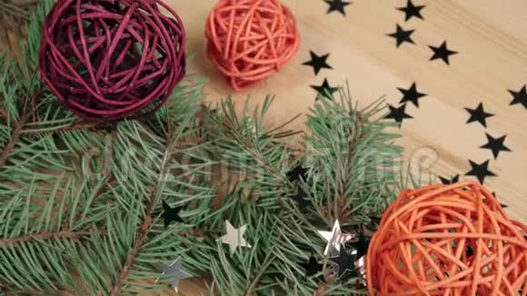 新年和圣诞节装饰一些礼物木制的彩色球和银星星靠近圣诞树树枝新年视频的预览图