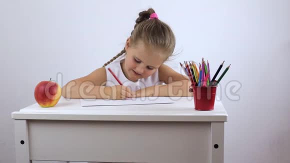 女孩是一个学龄前儿童坐在办公桌前勤奋地执行任务视频的预览图