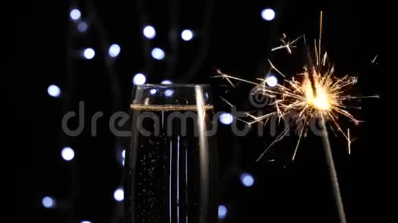 好香槟酒在玻璃旁边闪烁着明亮的火花背景中的灯光映衬着金色的香槟带闪闪发光的长笛视频的预览图