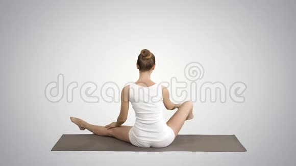 冷静的漂亮女人做瑜伽运动坐在瑜伽姿势的梯度背景视频的预览图