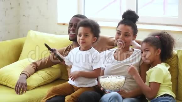 快乐的非裔美国人家庭爸爸妈妈和小孩看电视视频的预览图