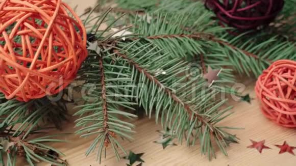 新年和圣诞节装饰一些礼物木制的彩色球和银星星靠近圣诞树树枝上的木头视频的预览图