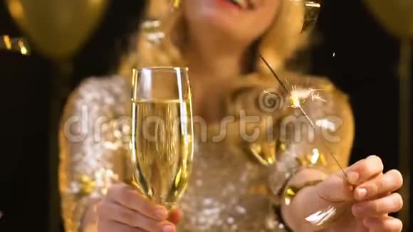 微笑的女人在镜头前展示香槟和孟加拉灯派对视频的预览图