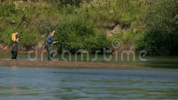 两个人拿着鱼竿抛着花车渔民在河上钓鱼视频的预览图
