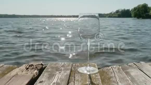 旧码头木制面板上的空酒杯蒸汽出现在玻璃上是因为茶叶被浸进去了视频的预览图