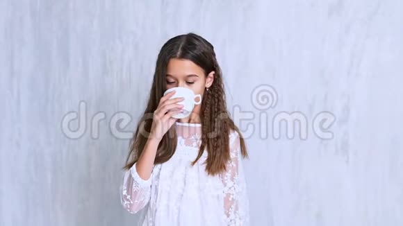 时尚漂亮的女学生喝热茶视频的预览图