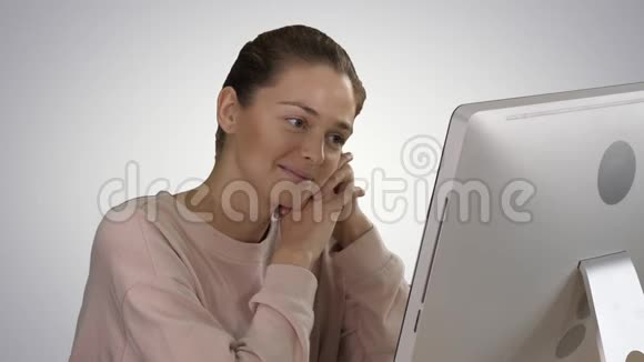 女人在电脑上看视频在渐变背景下大笑视频的预览图