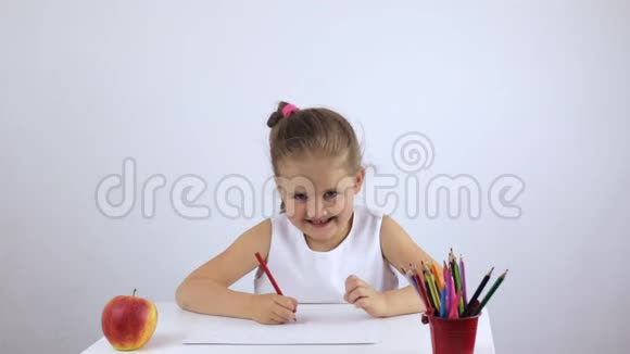 学龄前女孩坐在桌子旁笑着说话视频的预览图