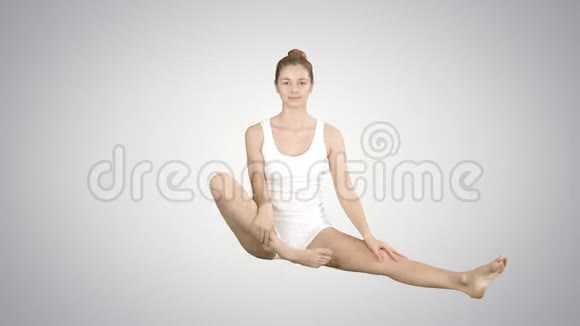 可爱的健身妇女锻炼瑜伽坐在莲花姿势和微笑后梯度背景视频的预览图