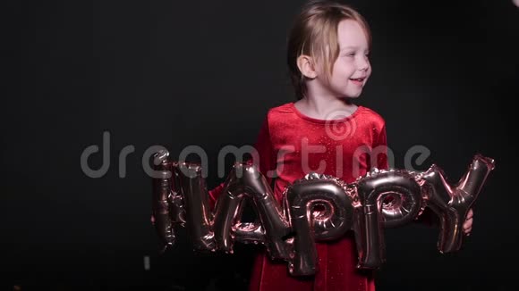漂亮的小女孩穿着红色的裙子带着气球快乐的字母视频的预览图