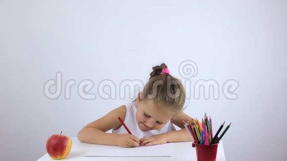 学龄前女孩坐在书桌前努力地画一幅画视频的预览图