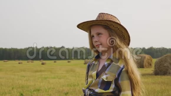 干草堆背景下乡下的牛仔戴着帽子的小母牛摆着前摄像头农村女孩视频的预览图