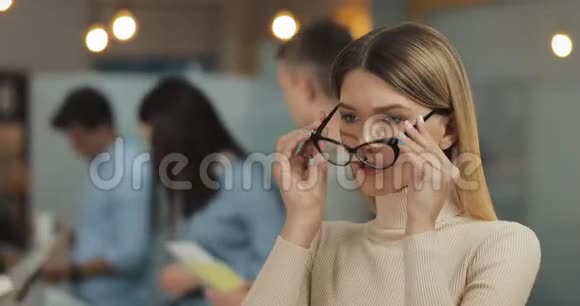 年轻成功的女商人戴着时尚眼镜看着办公室工作空间里的摄像机的画像视频的预览图
