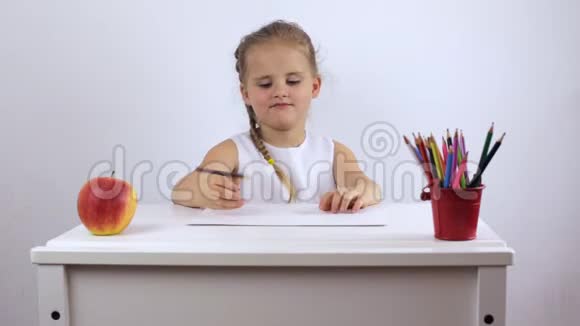 迷人的女孩心情愉快地用铅笔在相册上画画视频的预览图
