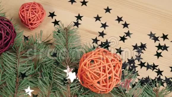 新年和圣诞节装饰一些礼物木制的彩色球和银星星靠近圣诞树树枝上的木头视频的预览图