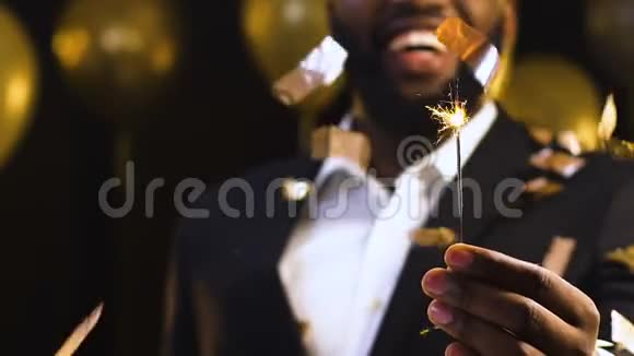 非洲裔美国男子向相机显示孟加拉灯新年公司聚会视频的预览图