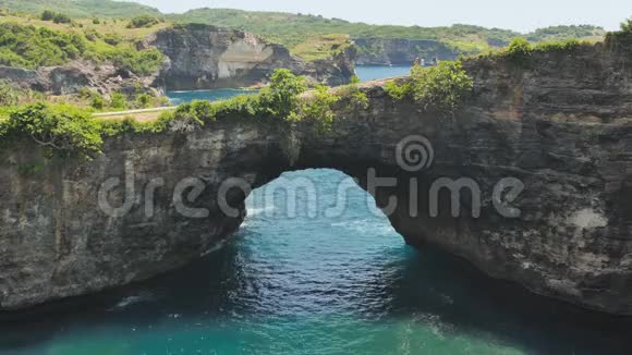 岩石海岸线石拱过海破碎海滩努沙佩尼达印度尼西亚视频的预览图