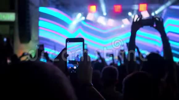 人们正在用智能手机拍摄歌手音乐会视频的预览图