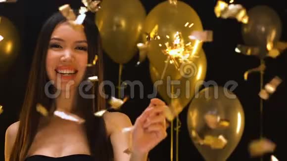 快乐的亚洲女人在飘落的纸屑下挥舞着孟加拉灯庆祝派对视频的预览图