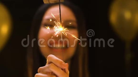 微笑的亚洲女人向镜头展示孟加拉灯新年公司聚会视频的预览图