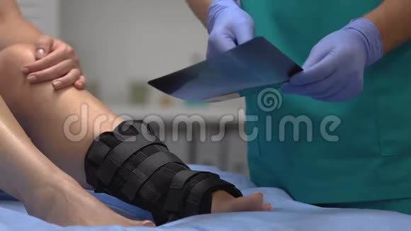 创伤学家向踝关节包扎病人解释x光检查结果医疗视频的预览图
