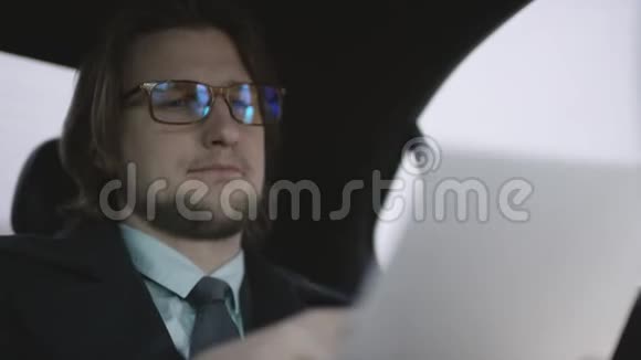 英俊的男子棕色头发穿着开心果衬衫灰色外套骑着车用钢笔检查文件视频的预览图