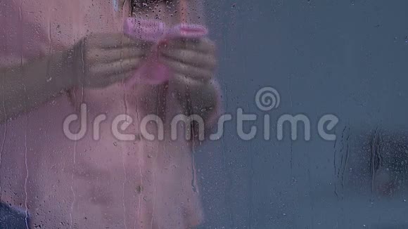 孕妇手里拿着粉色袜子摸着雨窗后的肚子威胁视频的预览图