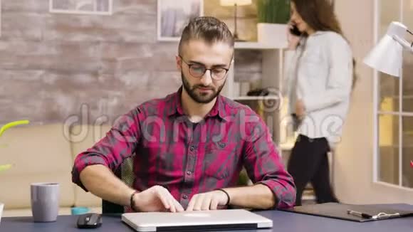 英俊的企业家一边喝咖啡一边在笔记本电脑上工作视频的预览图