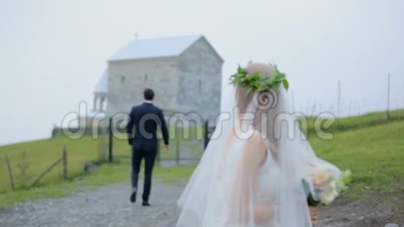 一个小教堂背景下戴着面纱的浪漫新娘视频的预览图