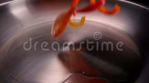 一束虾和胡椒落在加热的油上视频的预览图