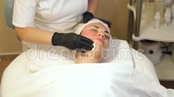 在生物复苏过程中美容师用棉签擦拭女孩的脸视频的预览图