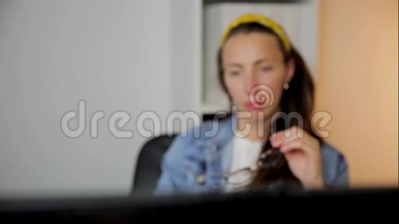 在家庭办公室工作的女人坐在办公桌前用严肃而集中的表情看着电脑屏幕数据分析视频的预览图