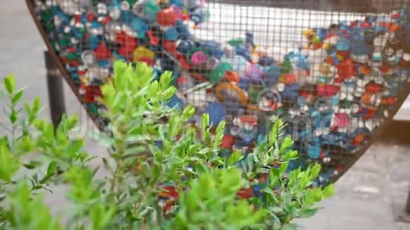 城市收集塑料垃圾和垃圾的概念收集的绿色植物灌木和心形铁笼视频的预览图