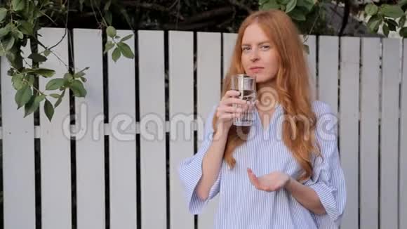红发女人在室外喝一杯水视频的预览图