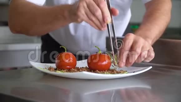 厨师放微绿装饰菜鹅肝或西红柿的釉球手的特写动作视频的预览图